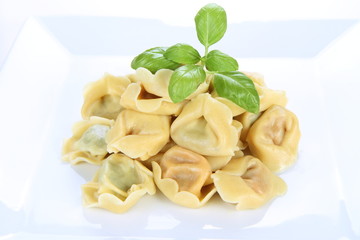 Tortellini on a plate decorated with fresh basil