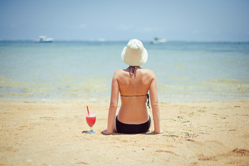 Fototapeta na wymiar relaks kobieta siedzi na piasku z koktajl