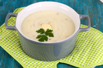 Mashed potatoes in saucepan on blue wooden table
