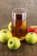 Useful apple juice with apples around on wooden table