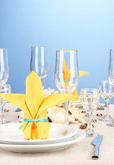 Table setting in white and yellow tones on color  background