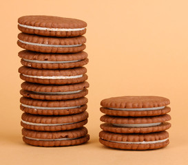 Chocolate cookies with creamy layer on beige background