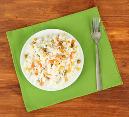 Risotto on color plate on wooden background