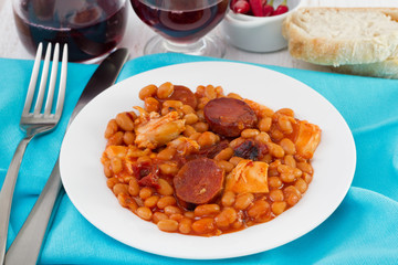 sausages with chicken and beans on the white plate