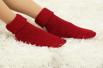 Female legs in colorful socks on  white carpet background