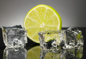 Ice cubes with lime on black background