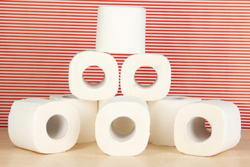 Rolls of toilet paper on striped red background