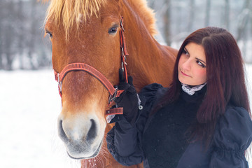 Beautiful woman and horse in winter
