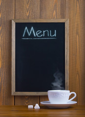 White cup and chalk board with the menu