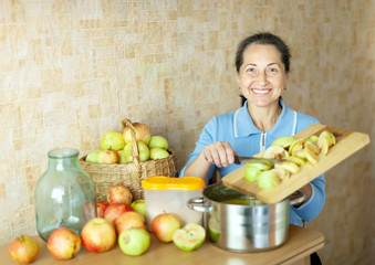 Obraz premium Woman cooks apple jam