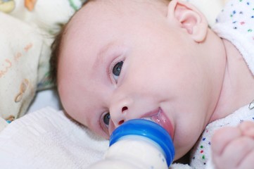 The baby eats from a small bottle (3 months)
