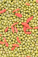 Green mung beans with red chinese wolfberry fruit background