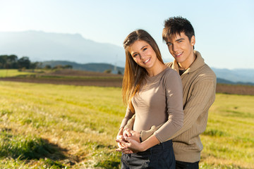 Portrait of young couple in countryside.