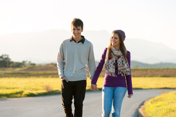 Young couple wandering in sunny countryside.