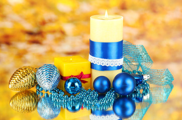 Obraz na płótnie Canvas Yellow candle with christmas decoration on bright background