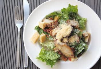 Chicken ceasar salad on wooden table