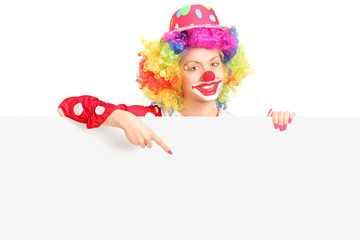 Female clown pointing with finger on a panel