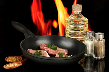 composition of raw meat and spices on black background close-up