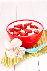 Cottage cheese in red bowl with sliced strawberries
