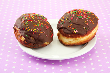 Tasty donuts on color plate on color background
