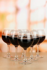Red wine in glass on room background