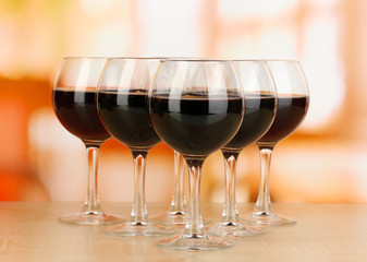 Red wine in glass on room background