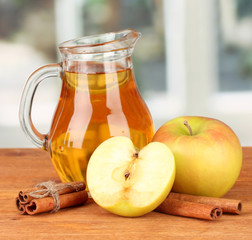 Full jug of apple juice and apple