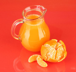 Full jug of tangerine juice, on color background