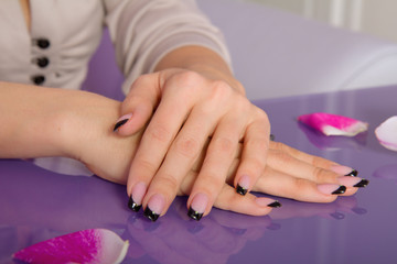 Fototapeta premium Woman hands with french manicure with crystals