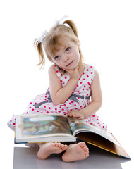 dreaming baby girl reading a book. isolated on white
