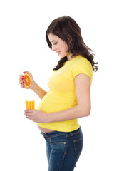 pregnant woman squeezing out orange juice. isolated on white