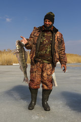 A man with a catch after ice fishing.