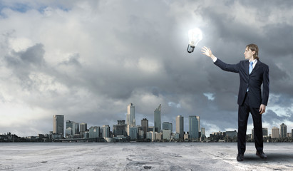 Businessman holding light bulb