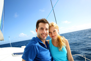 Portrait of couple sitting on the top of sailing boat