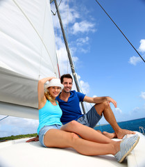 Obraz premium Cheerful couple cruising on a catamaran in Caribbean sea