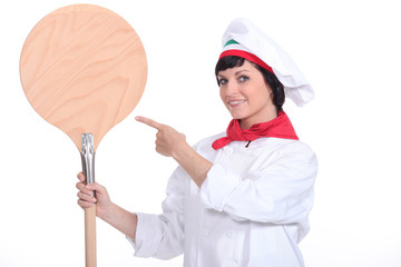 Pizza maker pointing to a pizza peel