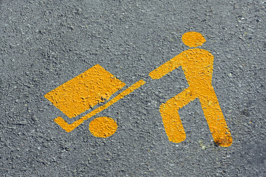 Yellow Man Who Load Merchandise Transport In Asphalt