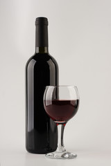 Bottle of red wine with glass