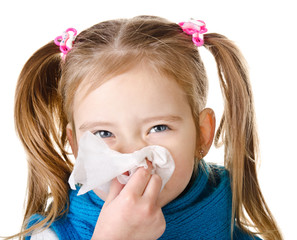Little girl blowing her nose in a great effort closeup isolated
