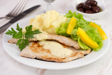 fried turkey with mashed potato and salad on the plate