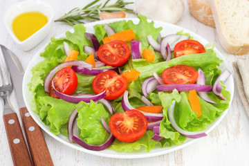 fresh salad on the white plate with bread and oil