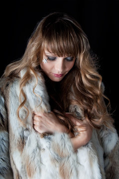 young beautiful woman with long hairs in fur coat