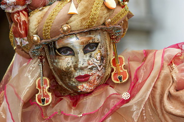 Person in Venetian costume attends Carnival of Venice.