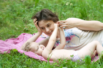 Naklejka na ściany i meble Girl and her mother are relaxing in the park