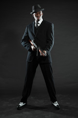 Black american mafia gangster man in suit with gun. - obrazy, fototapety, plakaty