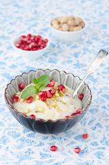 semolina dessert with pomegranate seeds and pistachios in a bowl