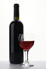 Bottle of red wine with glass