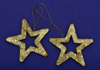 Fototapeta na wymiar Golden glittering star Christmas ornament isolated on a blue bac