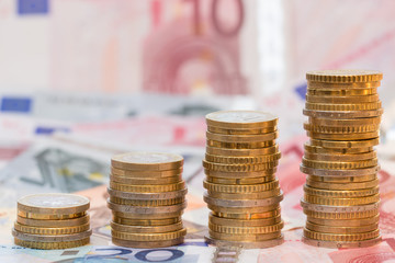 aufgebaute Stapel mit Euromünzen auf Banknoten