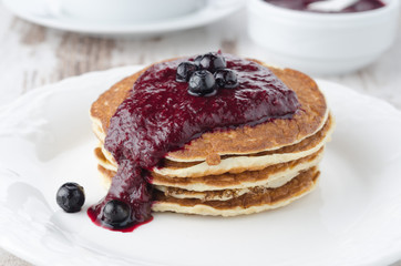 stack of pancakes with black currant jam on the plate,